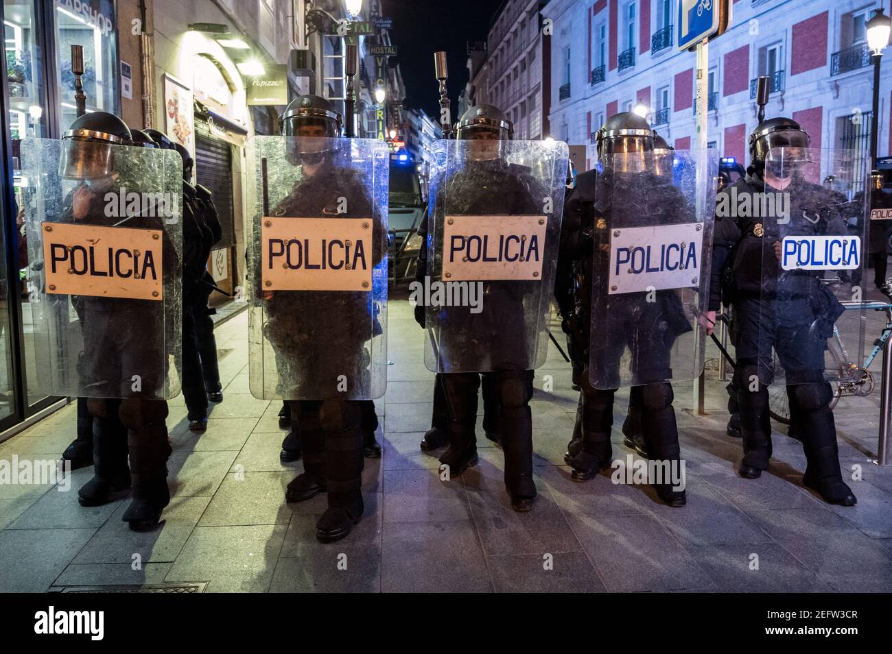 Madrid, Spanien. Februar 2021, 17th. Polizeibeamte halten während einer Demonstration gegen die Inhaftierung des spanischen Rappers Pablo Hasel Position für einige Liedtexte und Tweets, die die spanische Monarchie kritisieren. Quelle: Marcos del Mazo/Alamy Live News Stockfoto