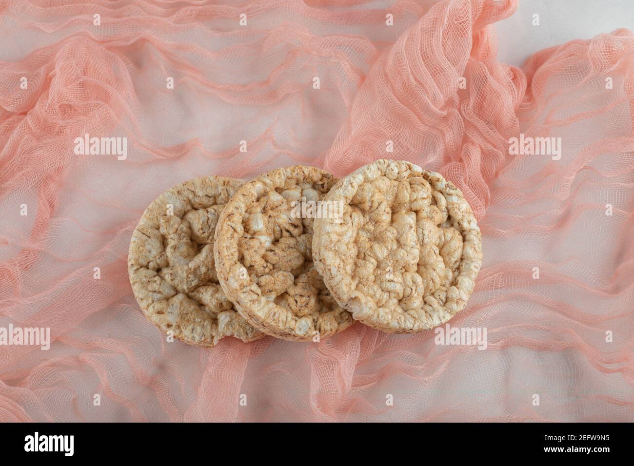 Köstliche runde Knäckebrot auf hellrosa Tischdecke Stockfoto