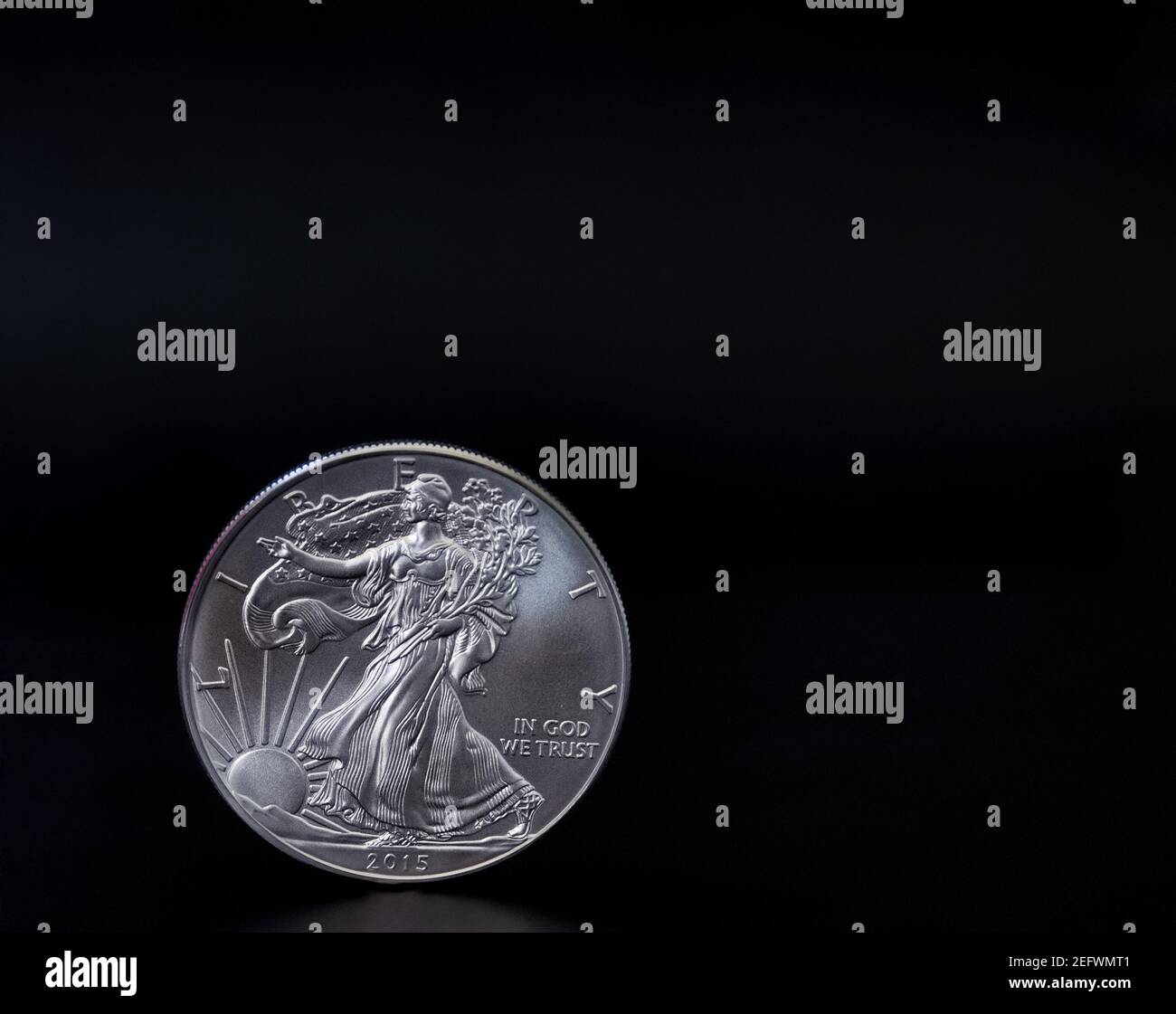 Eine 1 Unze amerikanische Silberadlermünze steht aufrecht auf schwarzem Hintergrund, mit Kopierraum Stockfoto