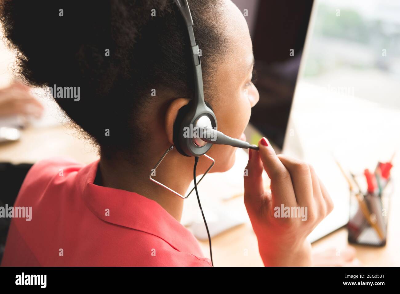 Schwarze Geschäftsfrau als Telemarketing-Kundendienstmitarbeiter mit Mikrofon-Headset im Büro arbeiten - Call Center-Job-Konzept, Rückansicht Stockfoto