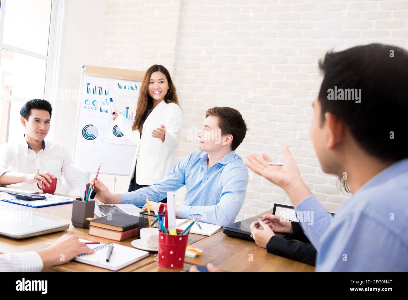 Junge asiatische Geschäftsfrau präsentiert ihre Arbeit auf dem Treffen Stockfoto