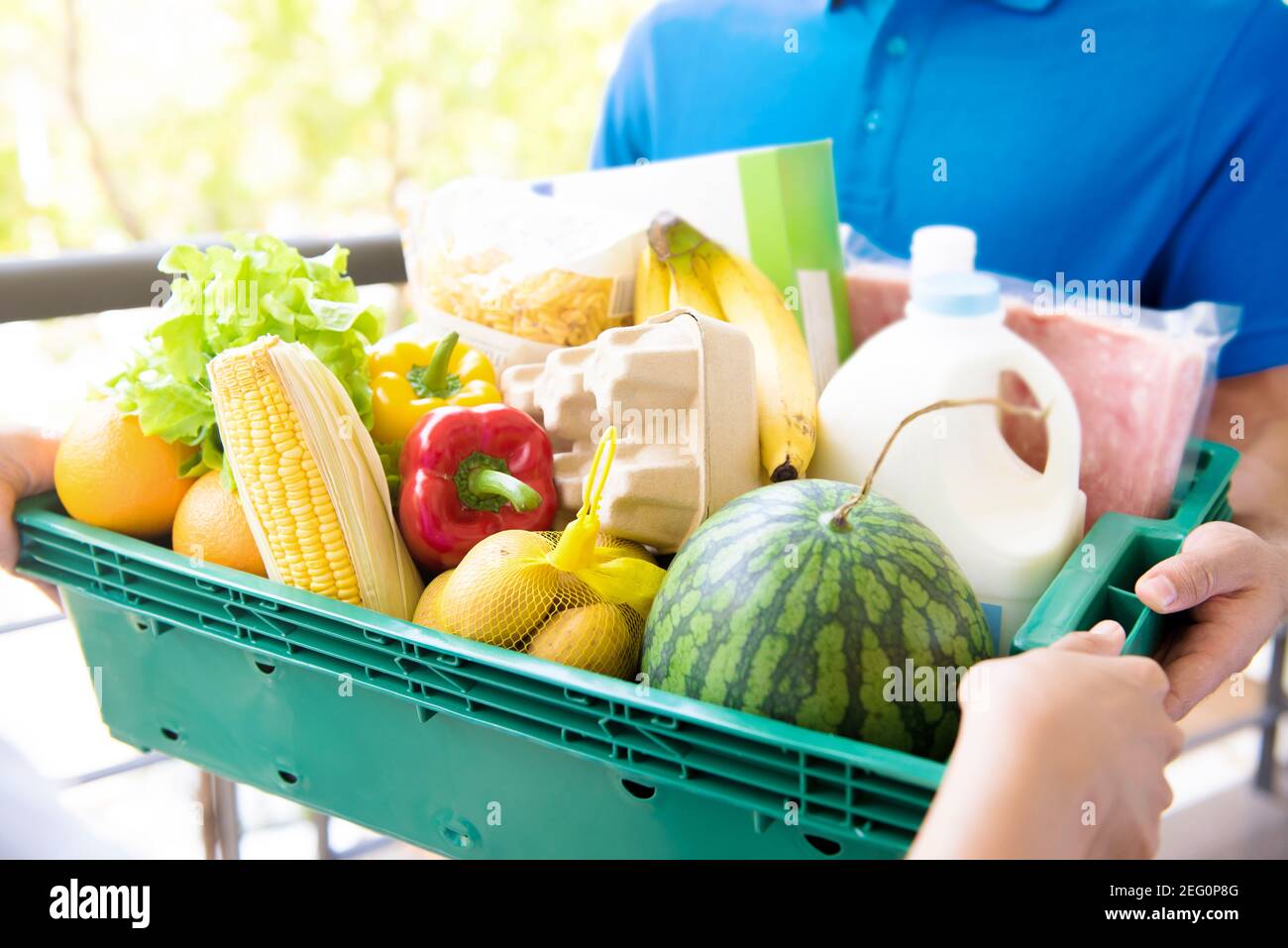 Delivery man liefert Lebensmittel an Kunden - Online-Lebensmitteleinkauf Servicekonzept Stockfoto