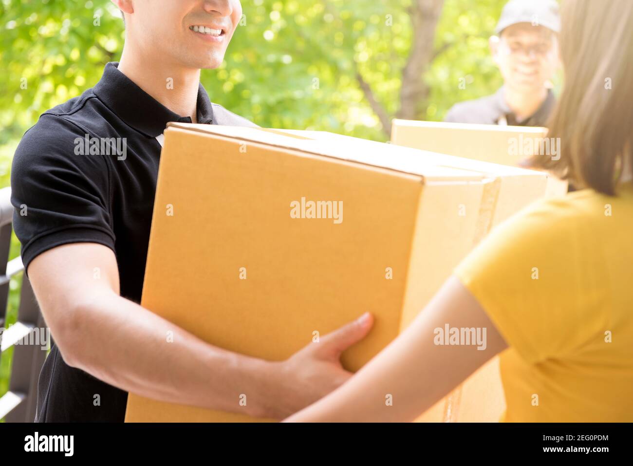 Lieferteam liefert Pakete an eine Frau Stockfoto