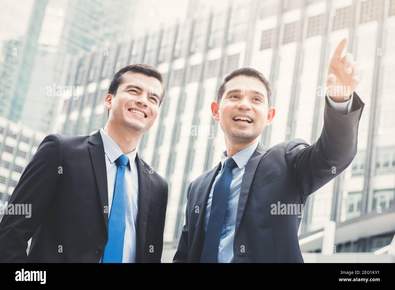 Zwei Geschäftsleute stehen mit einer Hand im Freien in der Stadt Aufzeigen von Konzepten für Geschäftspartner und Kollegen Stockfoto