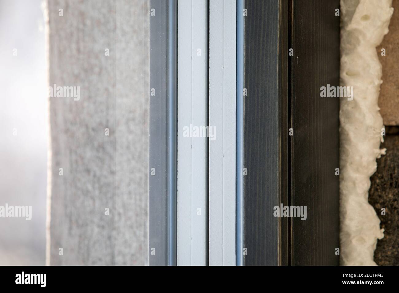 Installation von energieeffizienten Holzfenstern. Befestigungsschaum. Stockfoto