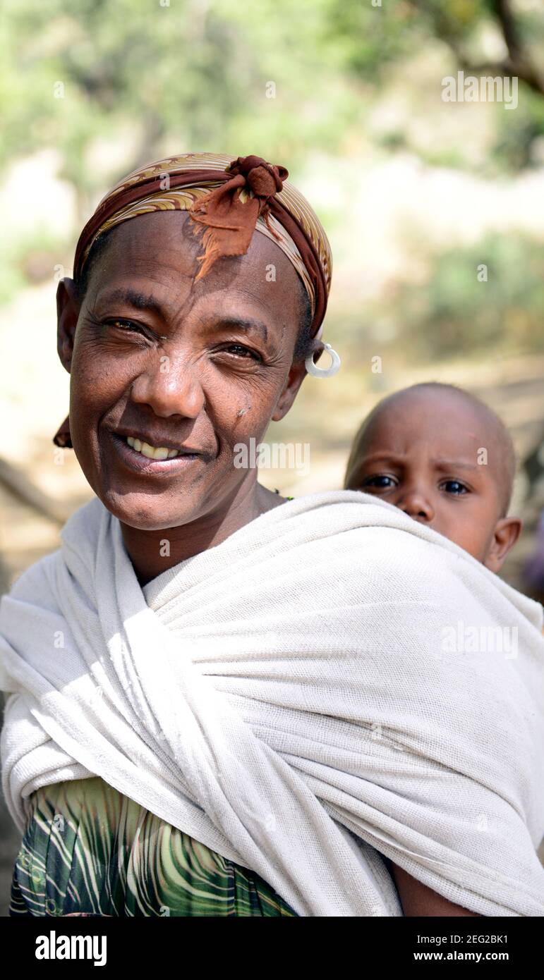 Eine Tigray-Frau, die ihr Baby trägt. Tigray Region, Äthiopien. Stockfoto