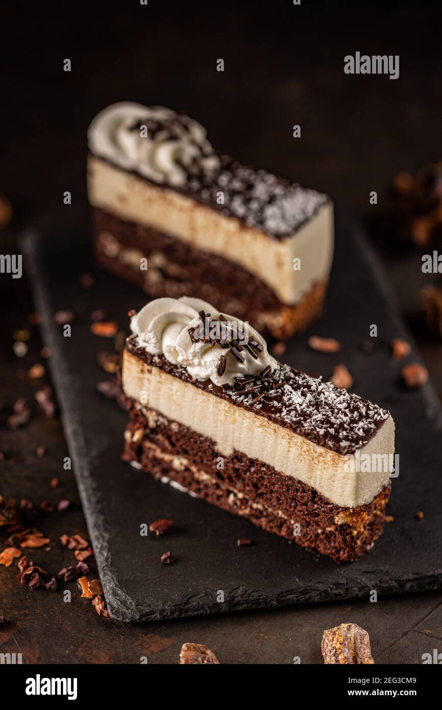Ein Stück leckeren hausgemachten Kuchen auf schwarzem Schiefer serviert Stockfoto