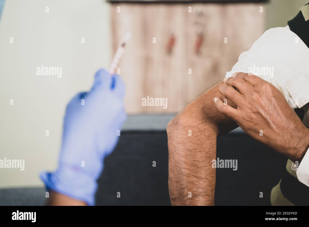 Nahaufnahme Hände des Arztes Hände gegeben Impfung Schuss älteren Patienten durch Spritze oder Unterlassung, Patient reiben seine Schulter zu Hause - Konzept der Stockfoto