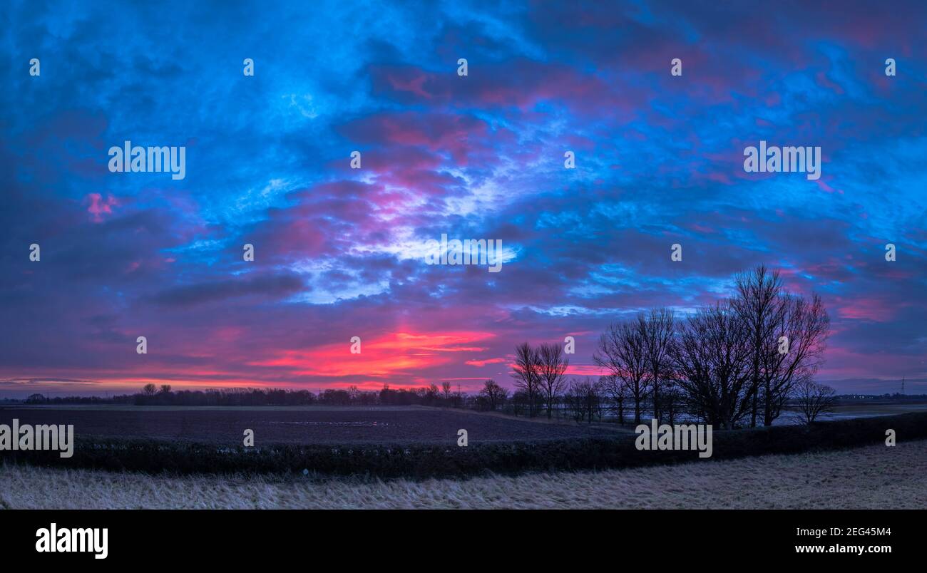 Spektakulärer Wintersonnenaufgang über flachem Ackerland Stockfoto