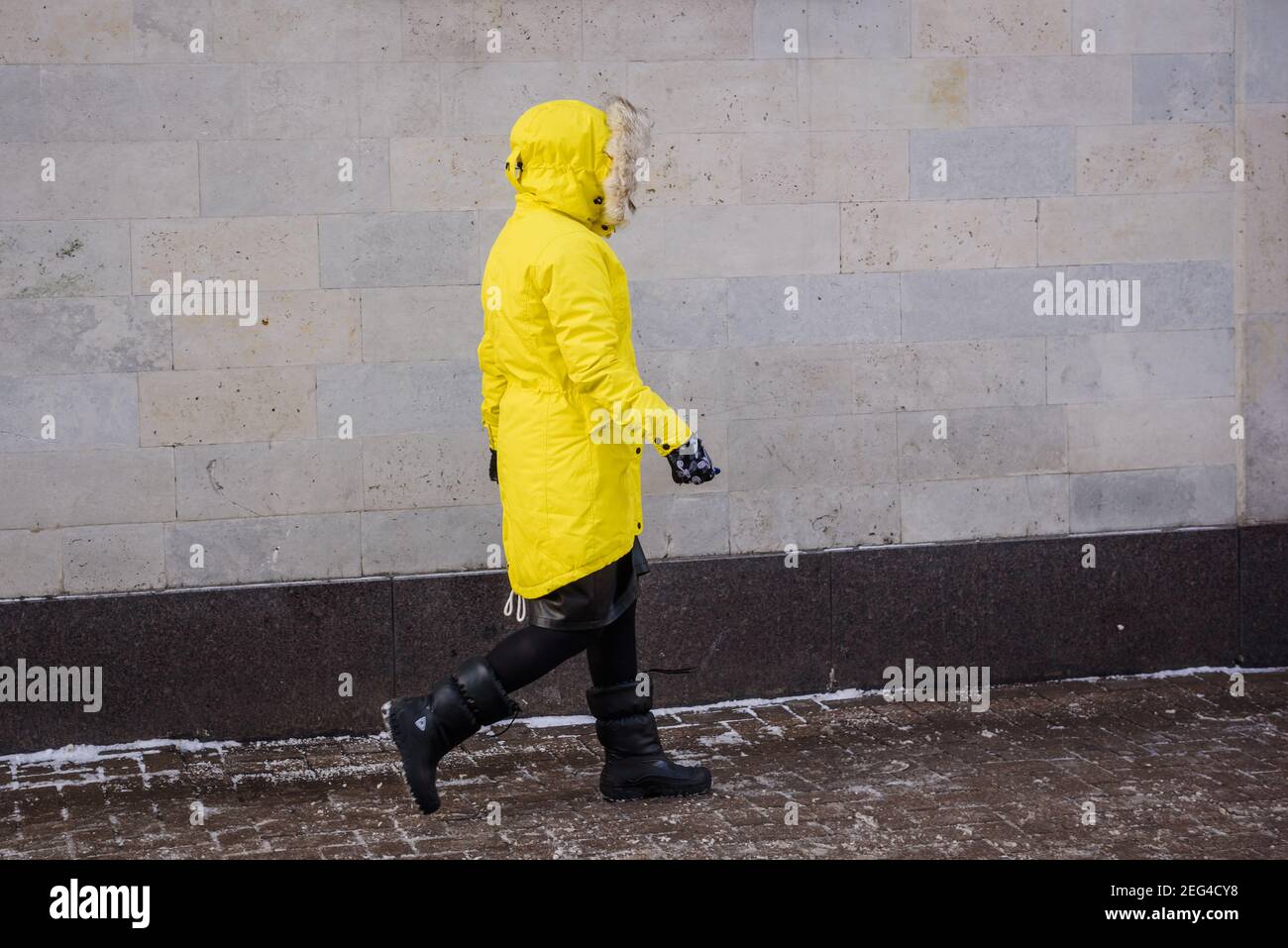 RIGA, LETTLAND. 12th. Februar 2021. Frau in warmer Kleidung geht auf der Straße. Kalter Wintertag. Stockfoto