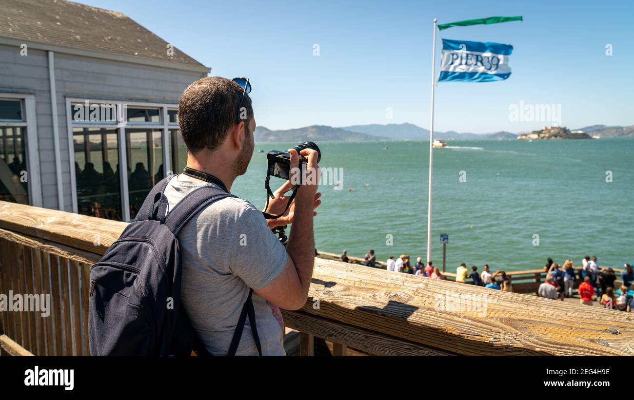 San Francisco, Kalifornien, USA - August 2019: Mann, der Alcatraz Island fotografiert, steht im Pier 39 der Fischerhafen Stockfoto