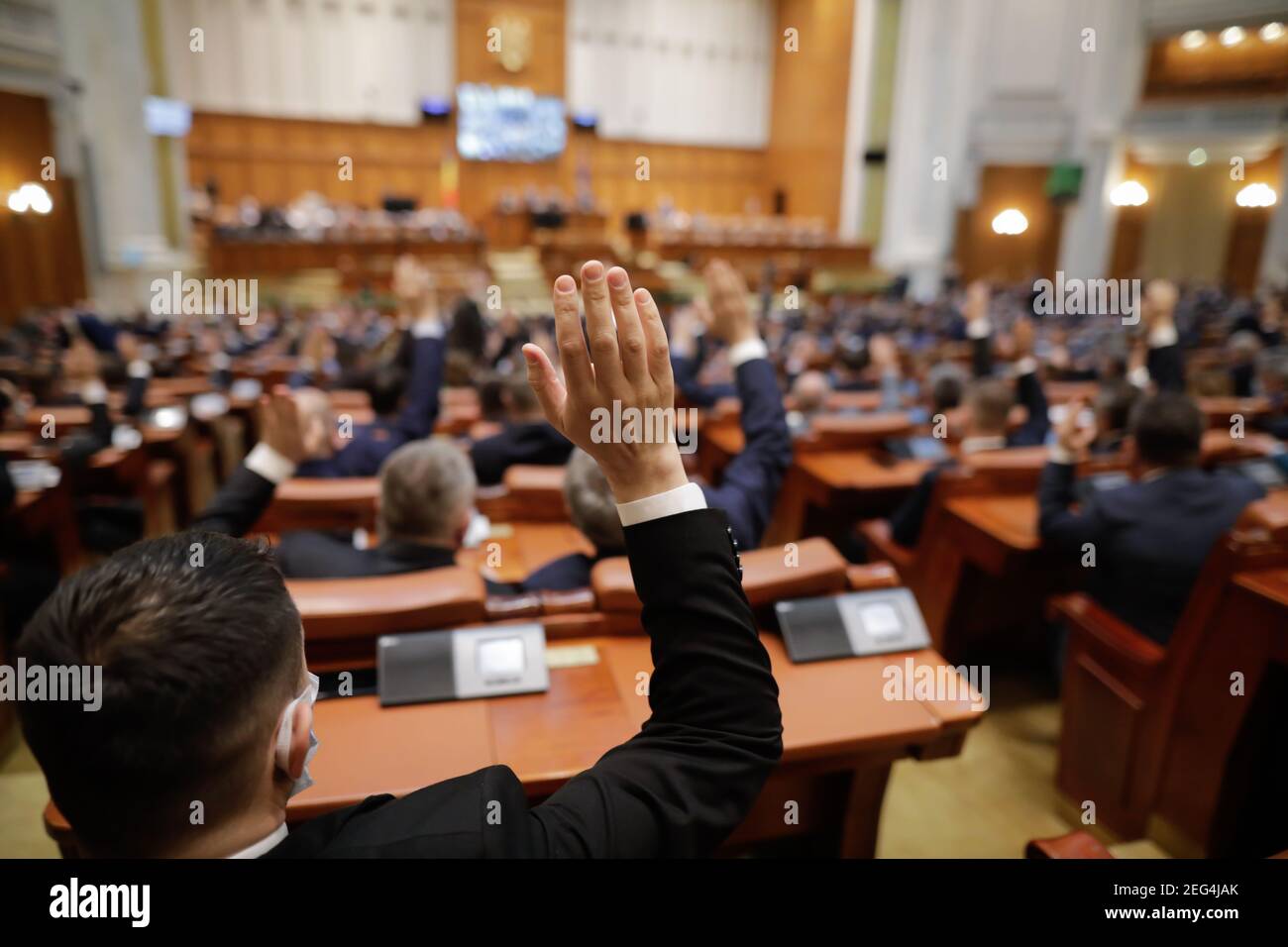 Bukarest, Rumänien - 17. Februar 2021: Geringe Schärfentiefe (selektiver Fokus) mit Details der rumänischen Parlamentsabgeordneten, die ihre Hände heben. Stockfoto