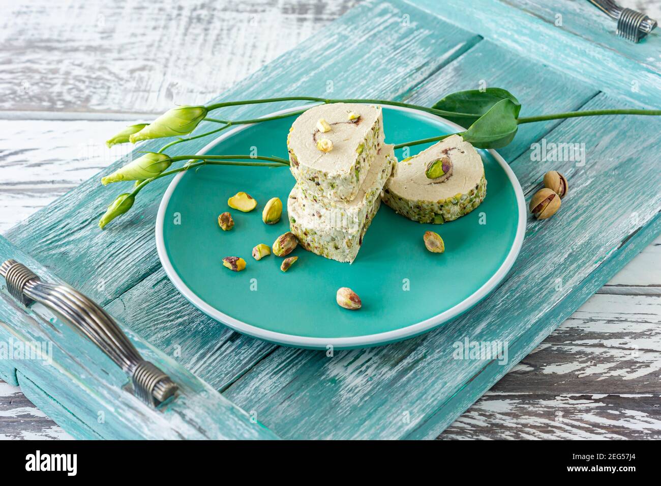 orient Pistaschio in Scheiben geschnitten Halva. Süßes Dessert auf einem Teller mit Blumen. Stockfoto