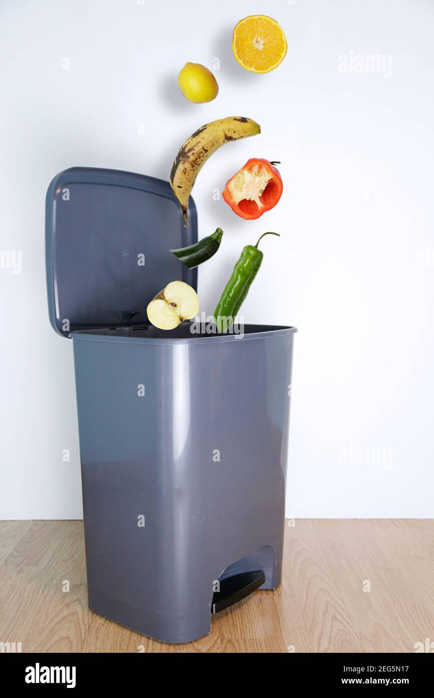 Essen in gutem Zustand, das in eine Mülltonne fällt. Konzept für Lebensmittelabfälle. Stockfoto