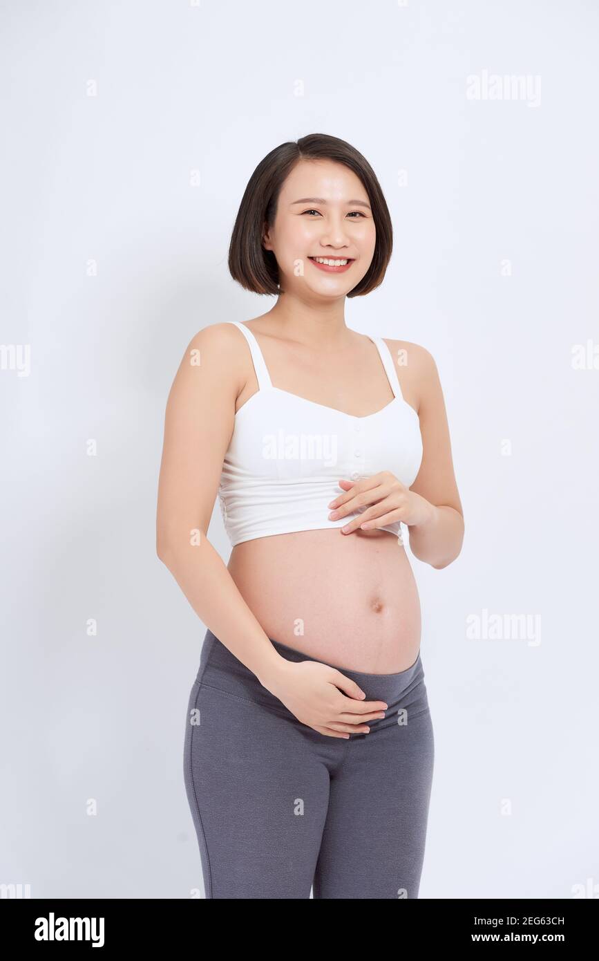 Schwangere Frauen beobachten den Magen glücklich wachsen. Stockfoto