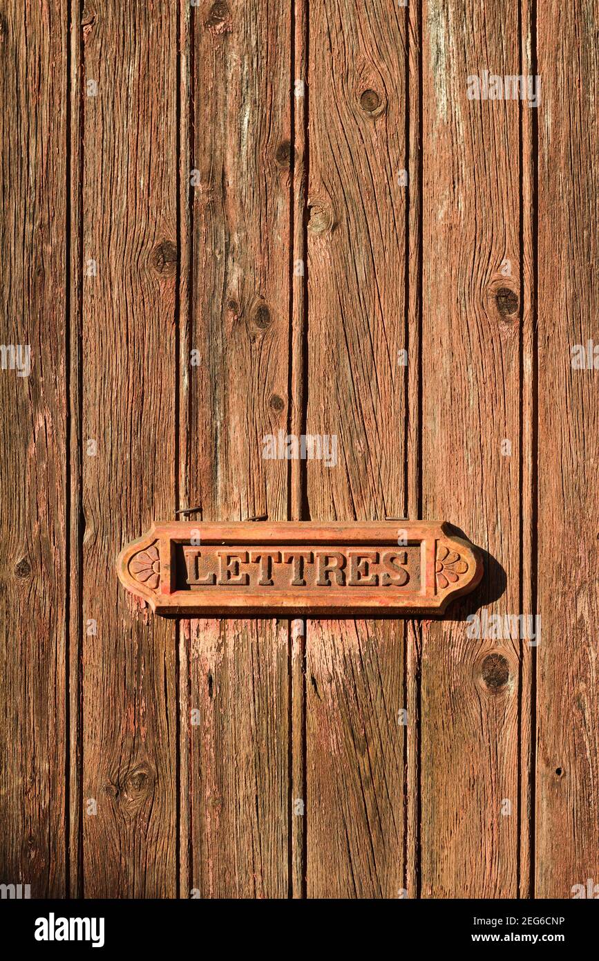 Alte Briefkasten auf einer braunen Holztür mit Inschrift 'lettres' auf französisch Stockfoto