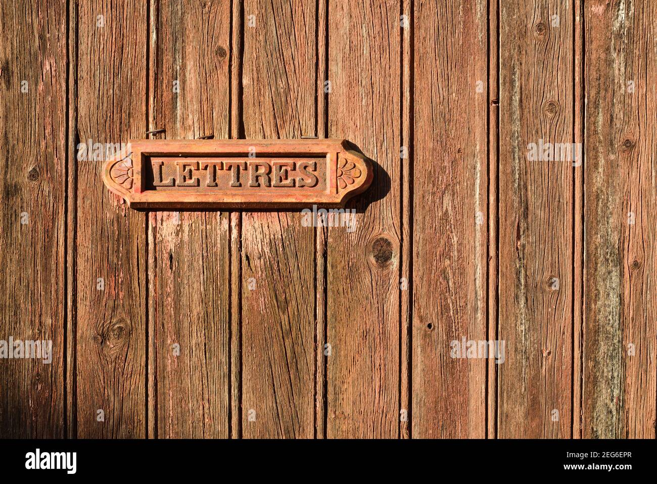 Alte Briefkasten auf einer braunen Holztür mit Inschrift 'lettres' auf französisch Stockfoto