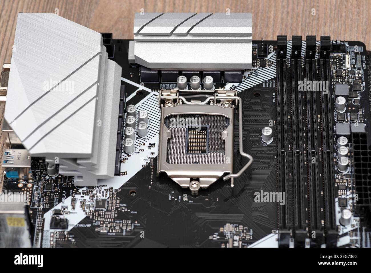 Ein modernes Desktop-Motherboard in schwarzer Farbe mit sichtbarem Sockel 1200 für die CPU, Speichersteckplätze DDR4 und Kühlkörper. Stockfoto