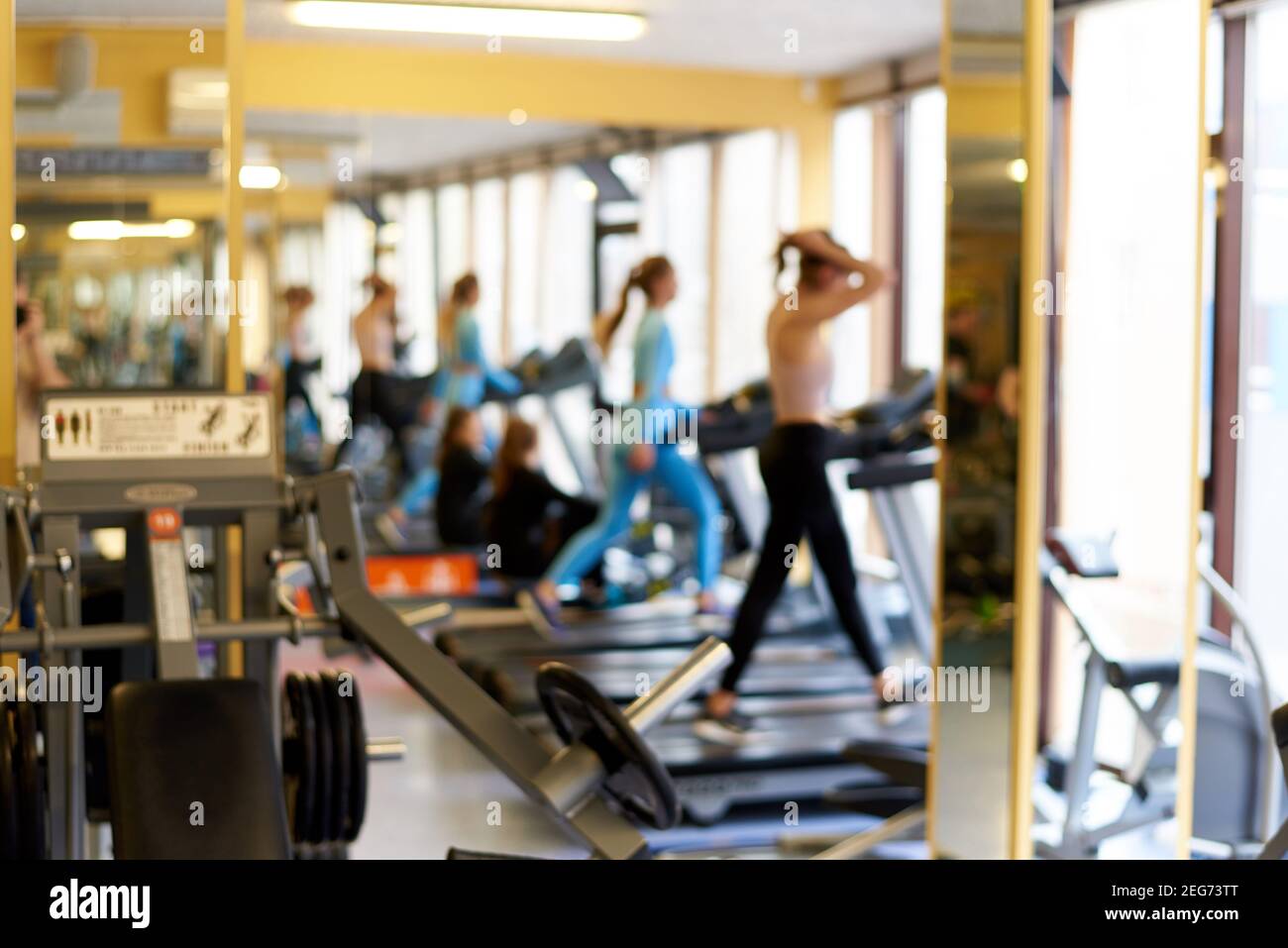 Defokussed Hintergrund von Laufbändern mit Menschen im Fitnessstudio. Stockfoto