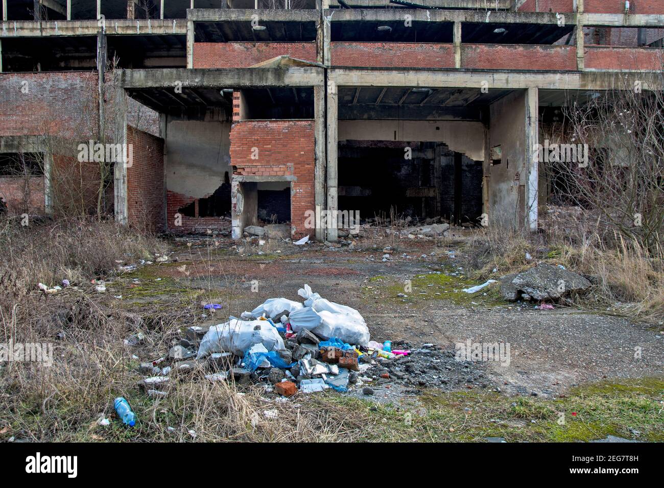 Eine hässliche, wilde Müllhalde in einer städtischen Nachbarschaft. Unverantwortliche Menschen werfen Müll in die Nähe der Straße und der Eisenbahnschienen. Stockfoto