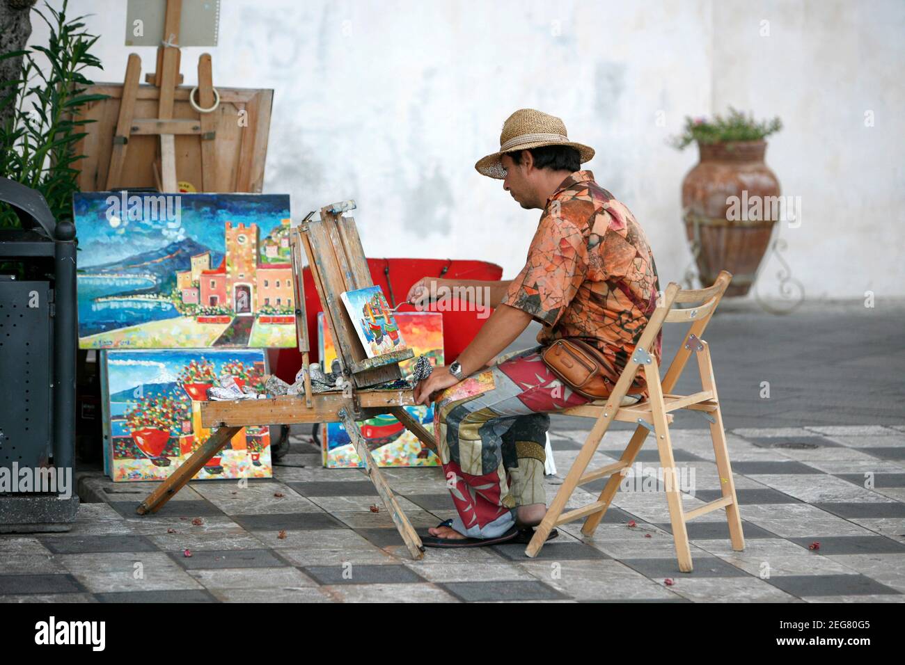 Ein Straßenkünstler und Maler auf einem Straßenmarkt in einer Gasse im Zentrum der Altstadt von Taormina in der Provinz Sizilien in Italien. Italien, Sizilien, Stockfoto