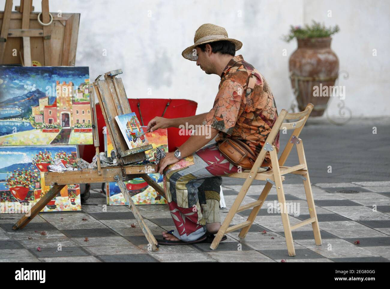 Ein Straßenkünstler und Maler auf einem Straßenmarkt in einer Gasse im Zentrum der Altstadt von Taormina in der Provinz Sizilien in Italien. Italien, Sizilien, Stockfoto