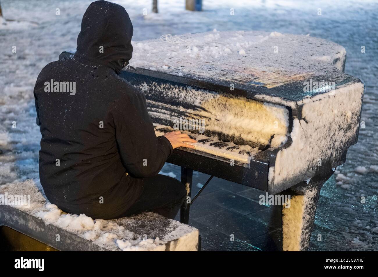 JERUSALEM, ISRAEL - 17. FEBRUAR: Ein Israeli spielt am Zion-Platz Klavier, während Schneefall am 17. Februar 2020 in Jerusalem, Israel. Jerusalem bedeckt durch ersten Schnee in sechs Jahren erreicht sieben bis 10 Zentimeter (drei bis vier Zoll) über Nacht. Stockfoto