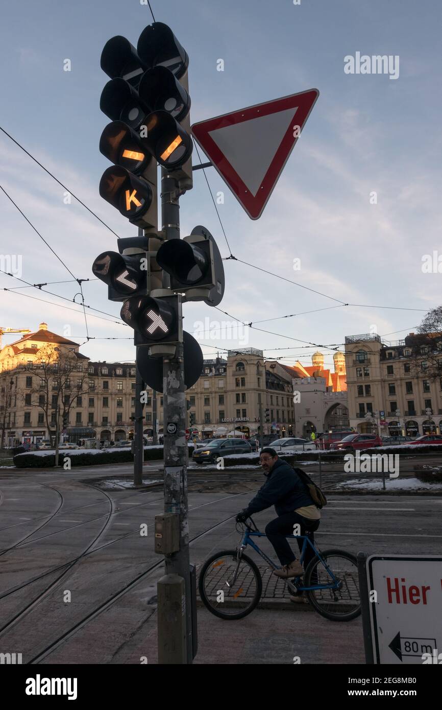 München, 13. Februar 2021: Die Ampel für Straßenbahnen wartet ein Radfahrer auf die grüne Ampel. Es gibt die Kathedrale Kirche unserer Lieben Frau Stockfoto