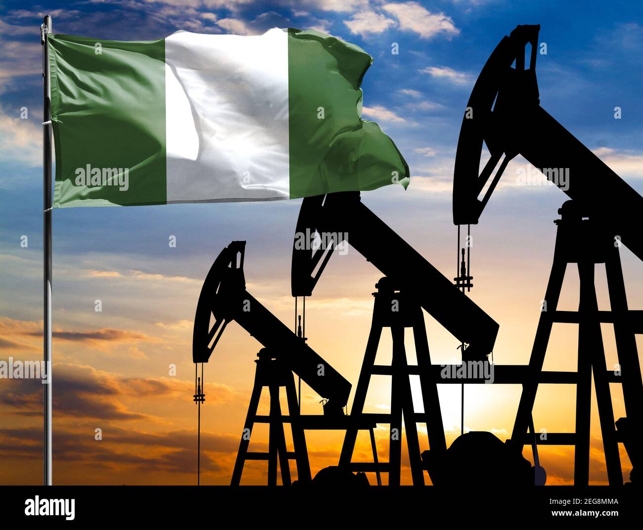 Ölbohrinseln vor dem Hintergrund des bunten Himmels und einer Fahnenstange mit der Flagge Nigerias. Das Konzept der Ölproduktion, Mineralien, Entwicklung von neuen Stockfoto