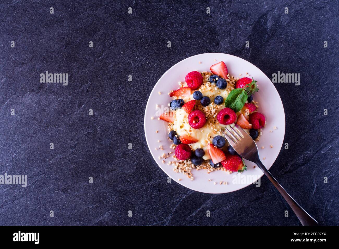 Gesundes Dessert mit zuckerfreiem Vanillepudding und frischen Beeren Auf einer Platte von oben mit Kopierplatz Stockfoto