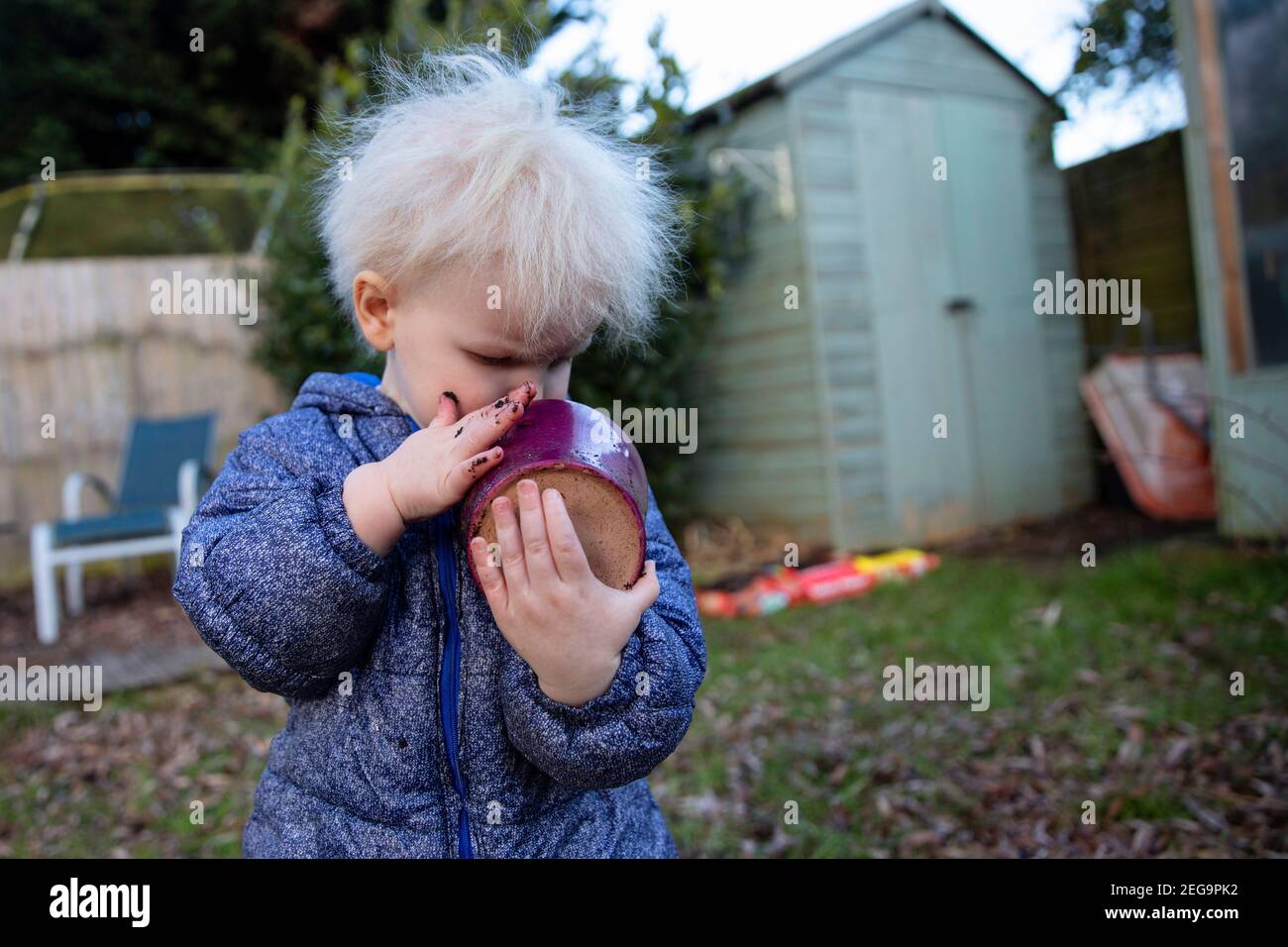 Nette junge Kleinkind Junge spielt im Garten mit einem Blumentopf Stockfoto