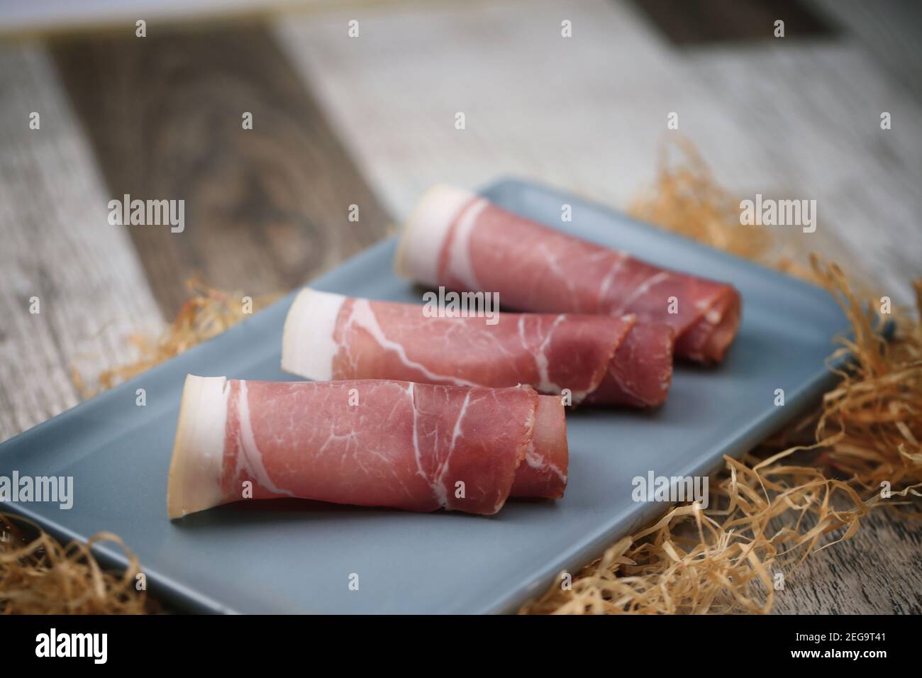 Schinkenscheiben mit Kräutern auf einem Tisch Stockfoto