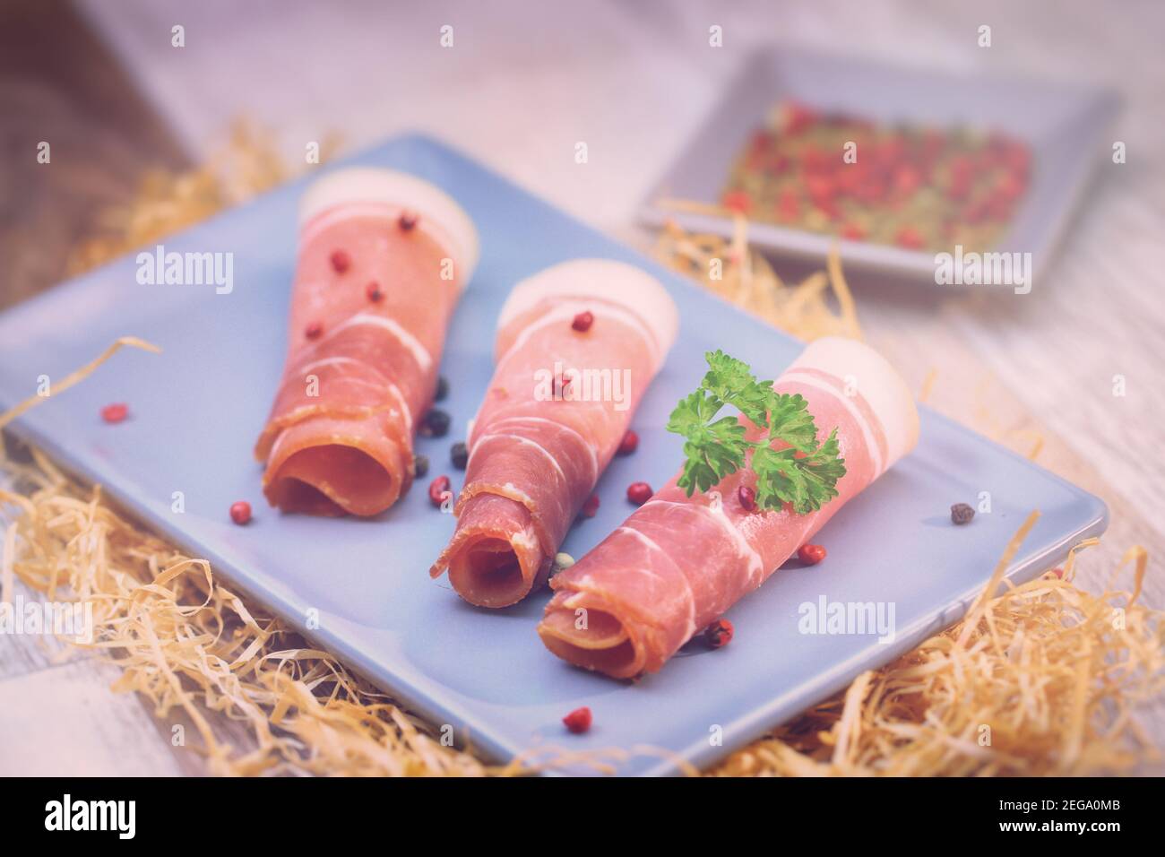 Schinkenscheiben mit Kräutern auf einem Tisch Stockfoto