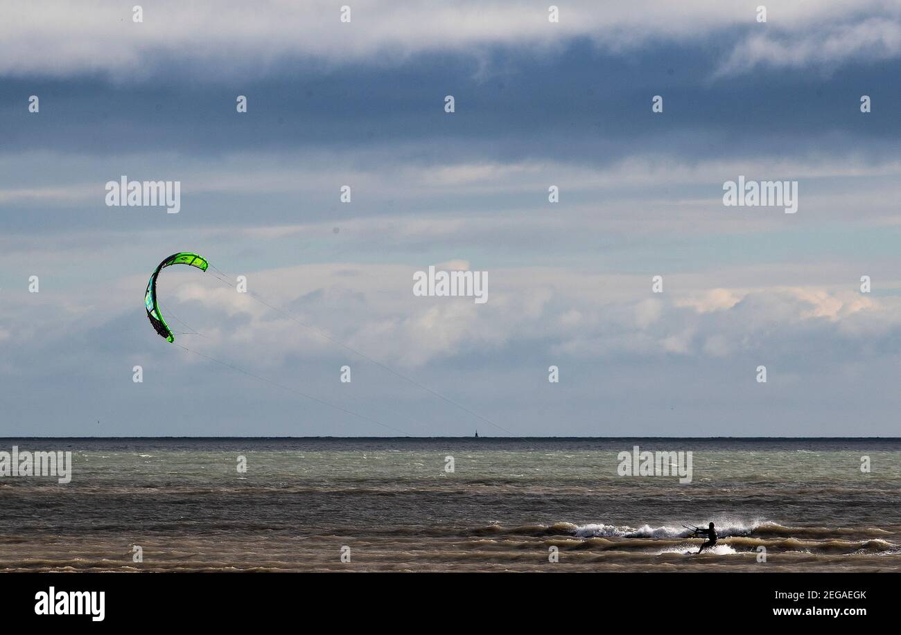 Ein Kitesurfer macht das Beste aus den Bedingungen am Dollymount Strand in Dublin, da Met Eireann eine Reihe von Statuswarnungen für Gelb heute und morgen herausgegeben hat. Bilddatum: Donnerstag, 18. Februar 2021. Stockfoto