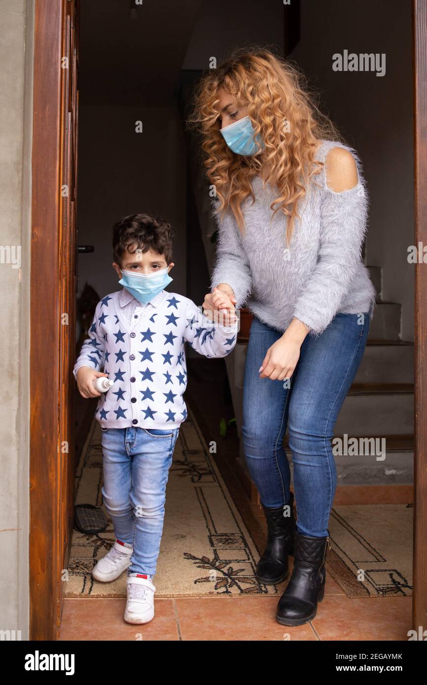 Mama und ihr Kleinkind Sohn trägt Gesichtsmasken immer bereit Zum Ausgehen Stockfoto