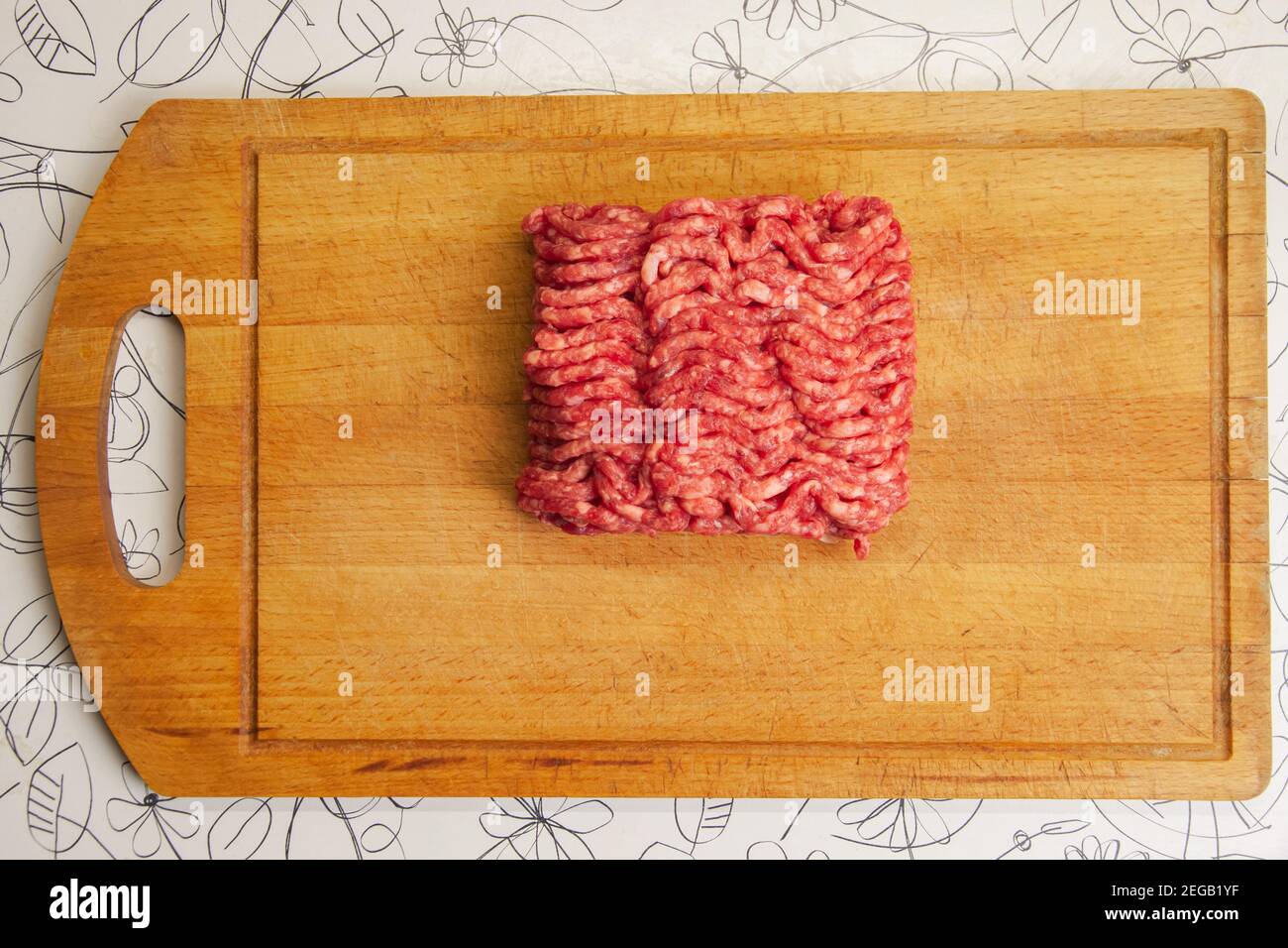 Hackfleisch auf einem alten Küchenbrett. Draufsicht Stockfoto