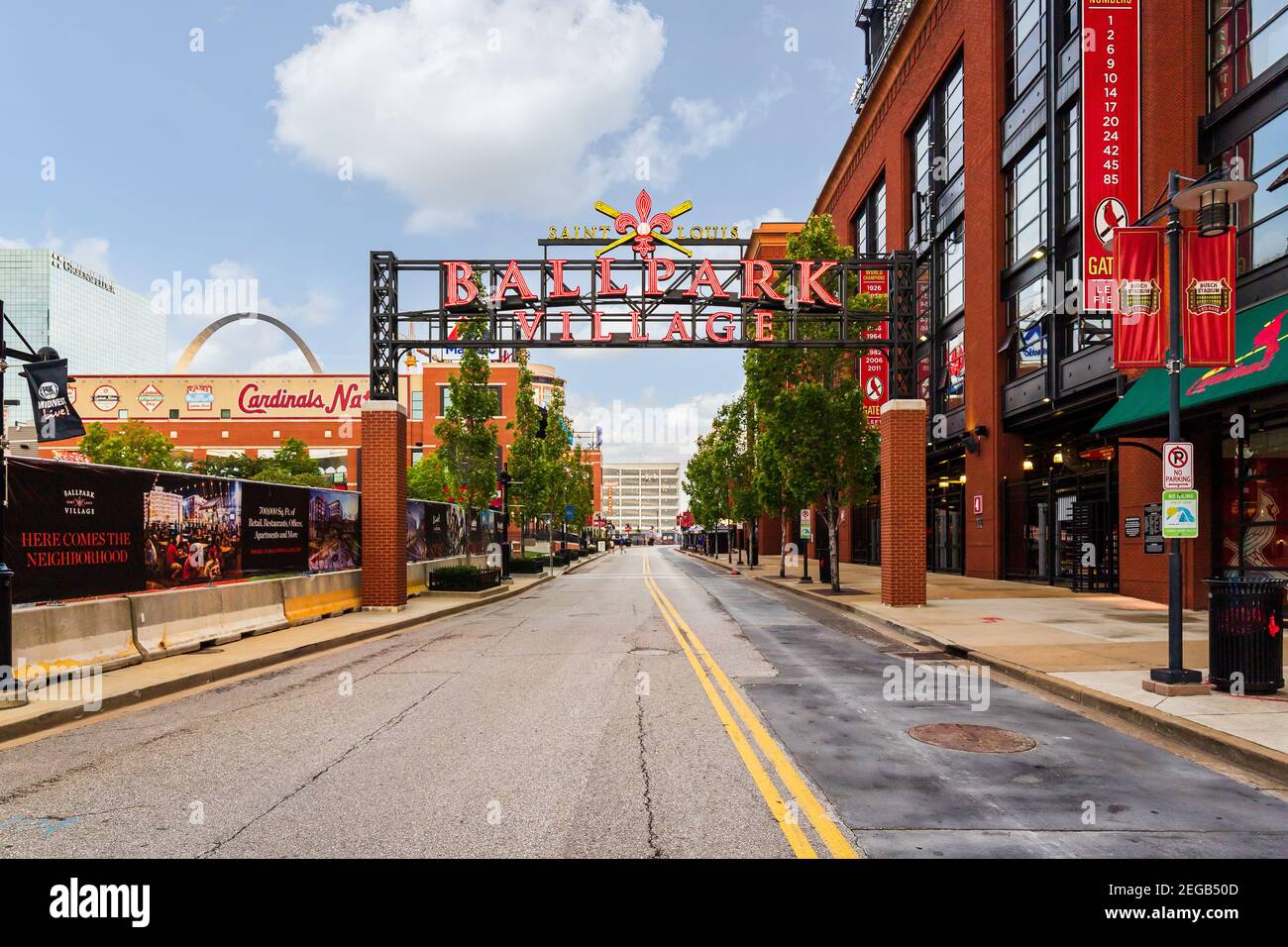 Ballpark Village Schild vor dem St. Louis Cardinals Busch Stadium des MLB mit Bars, Restaurants und dem Gateway Arch im Hintergrund. Stockfoto