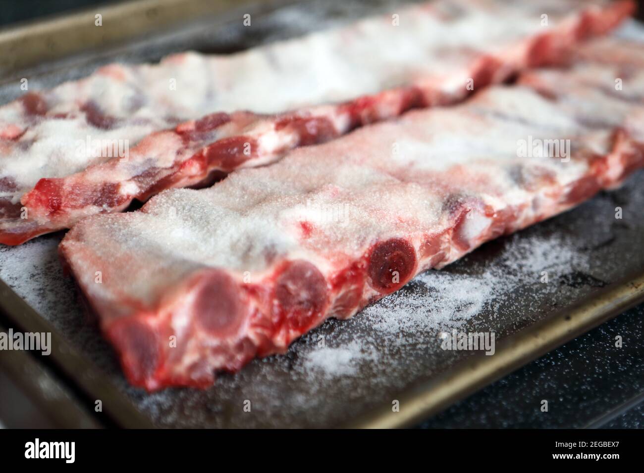 Schweinefleisch Spare Rippen mit Salz bedeckt, trocken einbräunend, die nach einer Stunde oder so vor dem Kochen abgewaschen wird Stockfoto