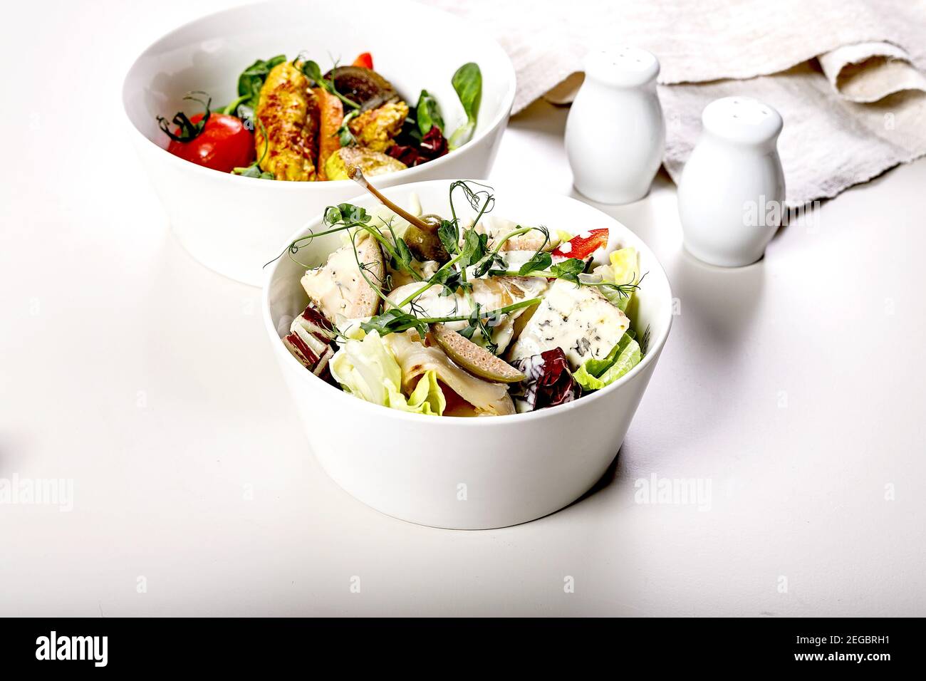 Köstlicher Salat mit Gemüse, Blauschimmelkäse, Kapern und leicht gesalzenem Meeresfisch. Meeresfrüchte. Mediterrane Küche. Heller Hintergrund Stockfoto