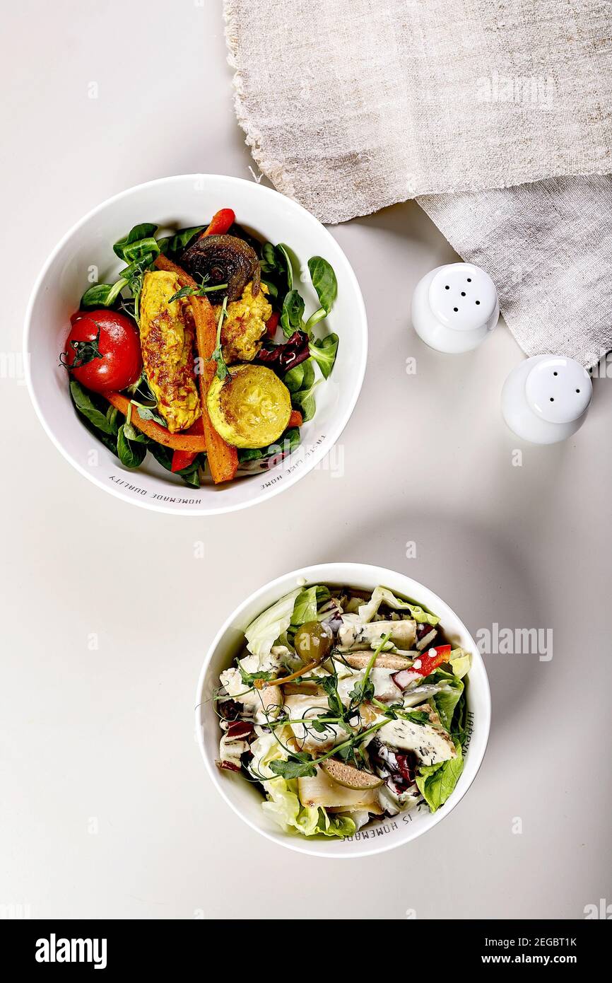 Köstlicher Salat mit Gemüse, Blauschimmelkäse, Kapern und Meeresfisch. Gebackenes Gemüse mit pute. Bio-Lebensmittel. Mediterrane Küche. Heller Hintergrund Stockfoto