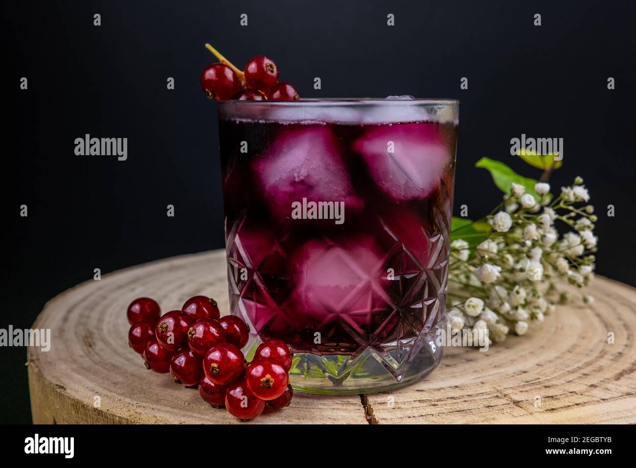 Glas Johannisbeere Wasser dunklen Hintergrund, Holztisch Stockfoto