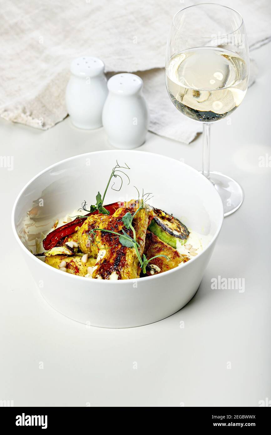Putenfilet gebacken mit gegrilltem Gemüse und Safran. Ein Glas Weißwein. Köstliche und gesunde Gourmet Dinner Rezepte. Mediterrane Küche. F Stockfoto