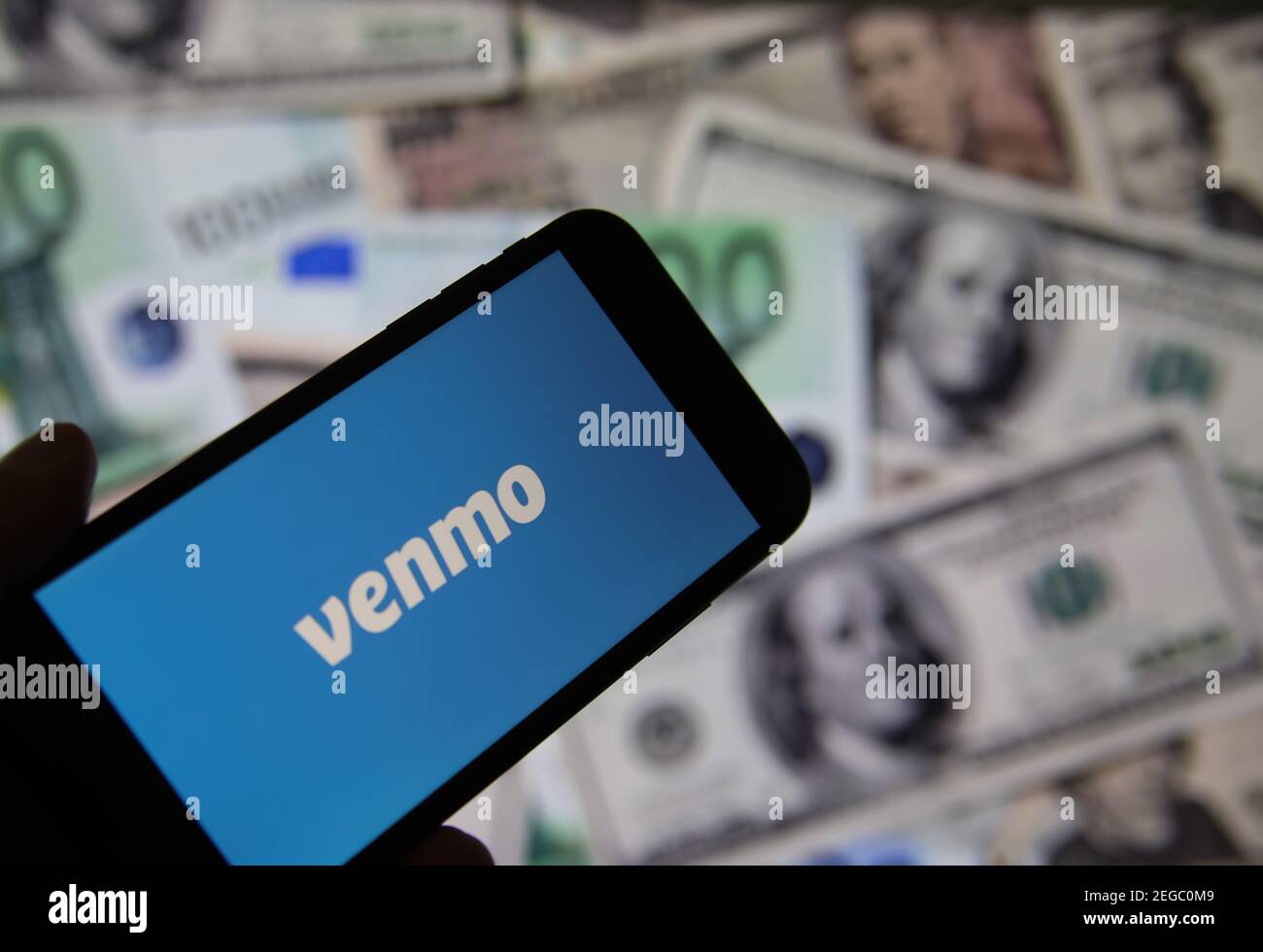 Viersen, Deutschland - Februar 9. 2020: Nahaufnahme von Smartphone-Bildschirm mit Logo-Schriftzug von Online-Geldtransfer-Service venmo, verschwommene Banknoten backgr Stockfoto
