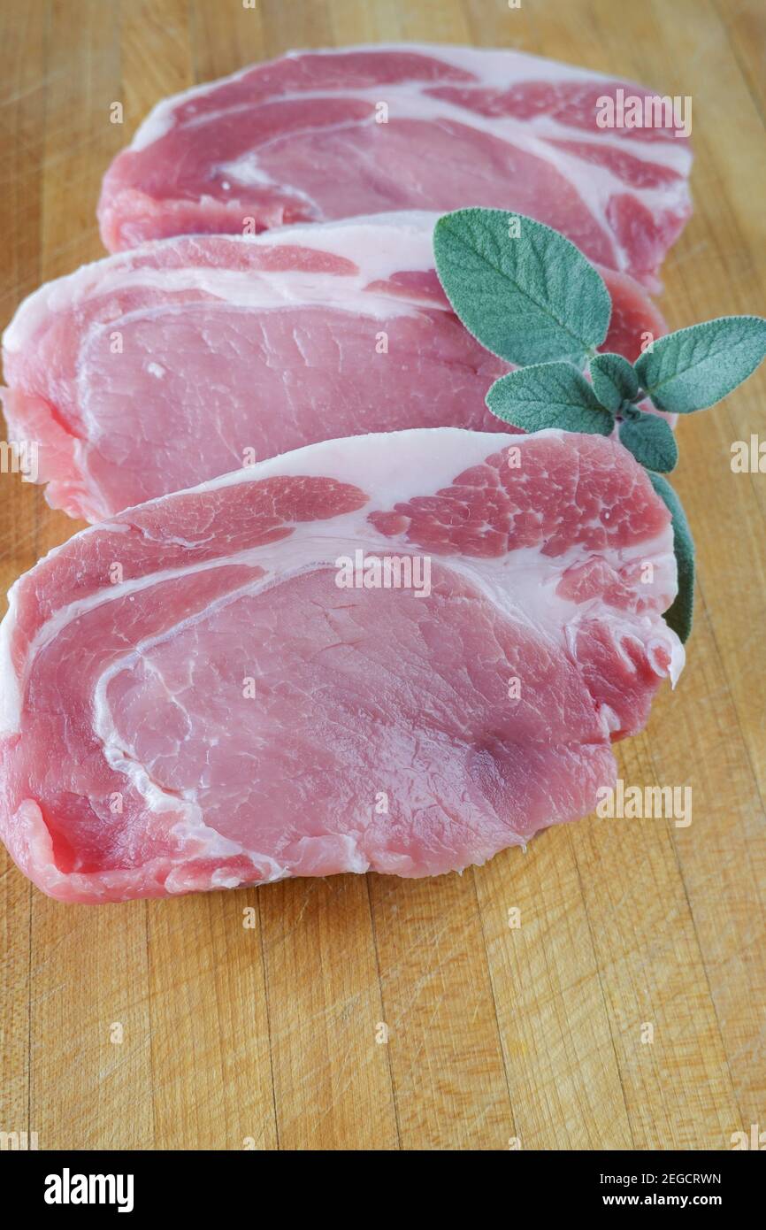 Rohe, knochenlose Koteletts aus Schweinefleisch auf einer Holzküche schneiden Platine Stockfoto