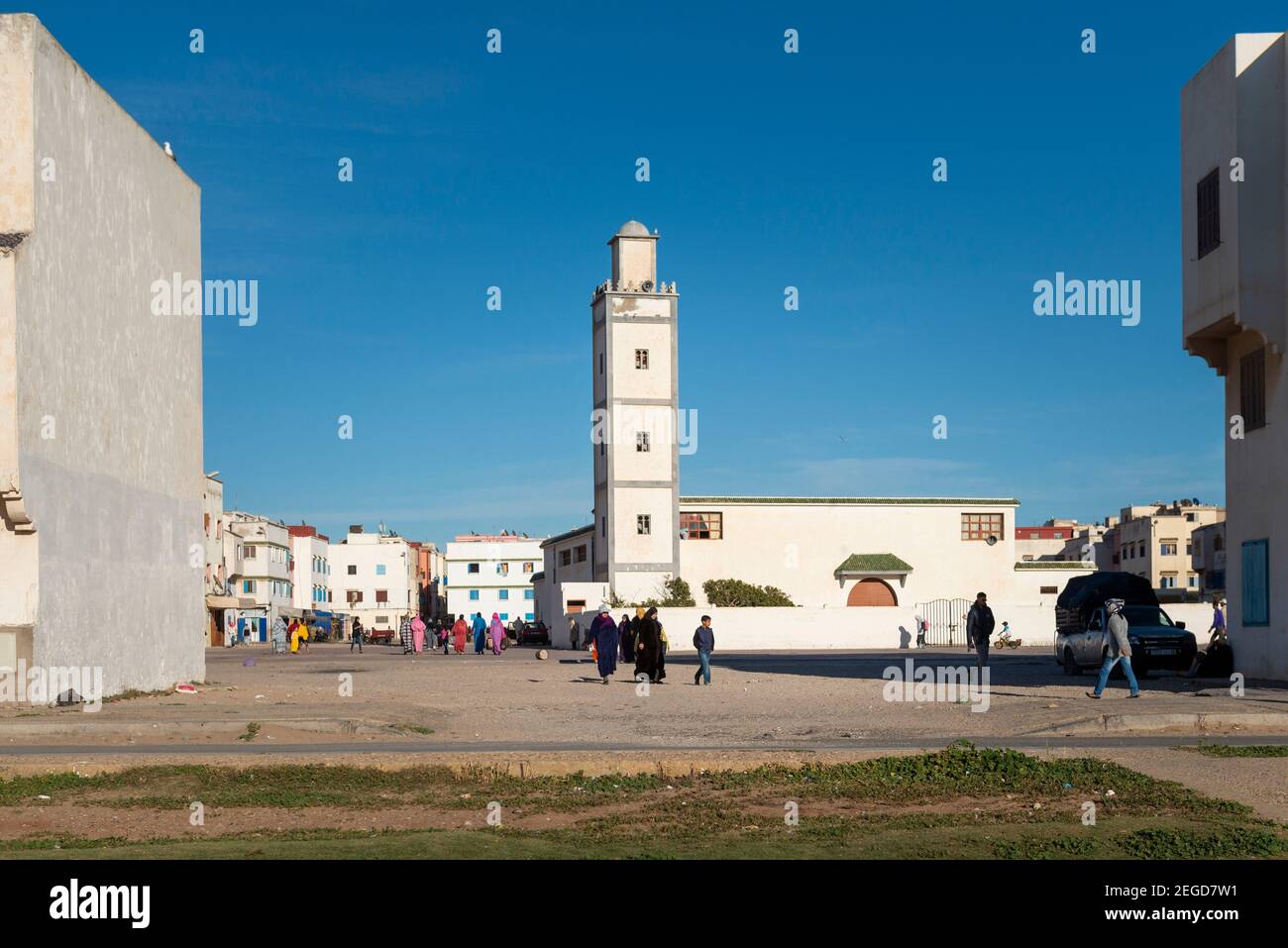 Essaouira, Marokko - 15. April 2016: Straßenszene in einem Wohnviertel der Stadt Essaouira, mit Menschen zu Fuß in einer Straße und einer Moschee Stockfoto