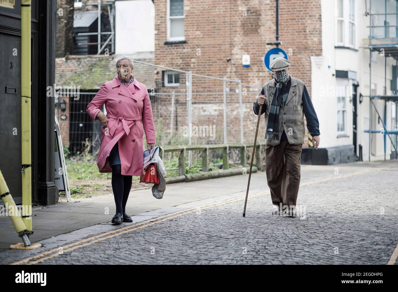 Ein älteres Paar, das die gepflasterte Straße mit 19 Masken hinuntergeht, Margate, Kent. Stockfoto