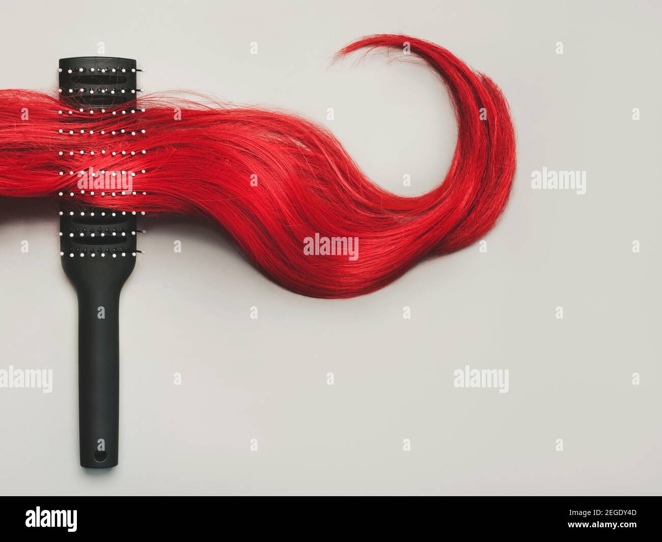 Haarbürste mit Verschluss der weiblichen roten Haare auf grau Hintergrund.Friseur Salon und Frisuren Konzept Stockfoto Haarbürste mit Verschluss der weiblichen roten Haare auf grau Hintergrund.Friseur Salon und Frisuren Konzept Stockfoto