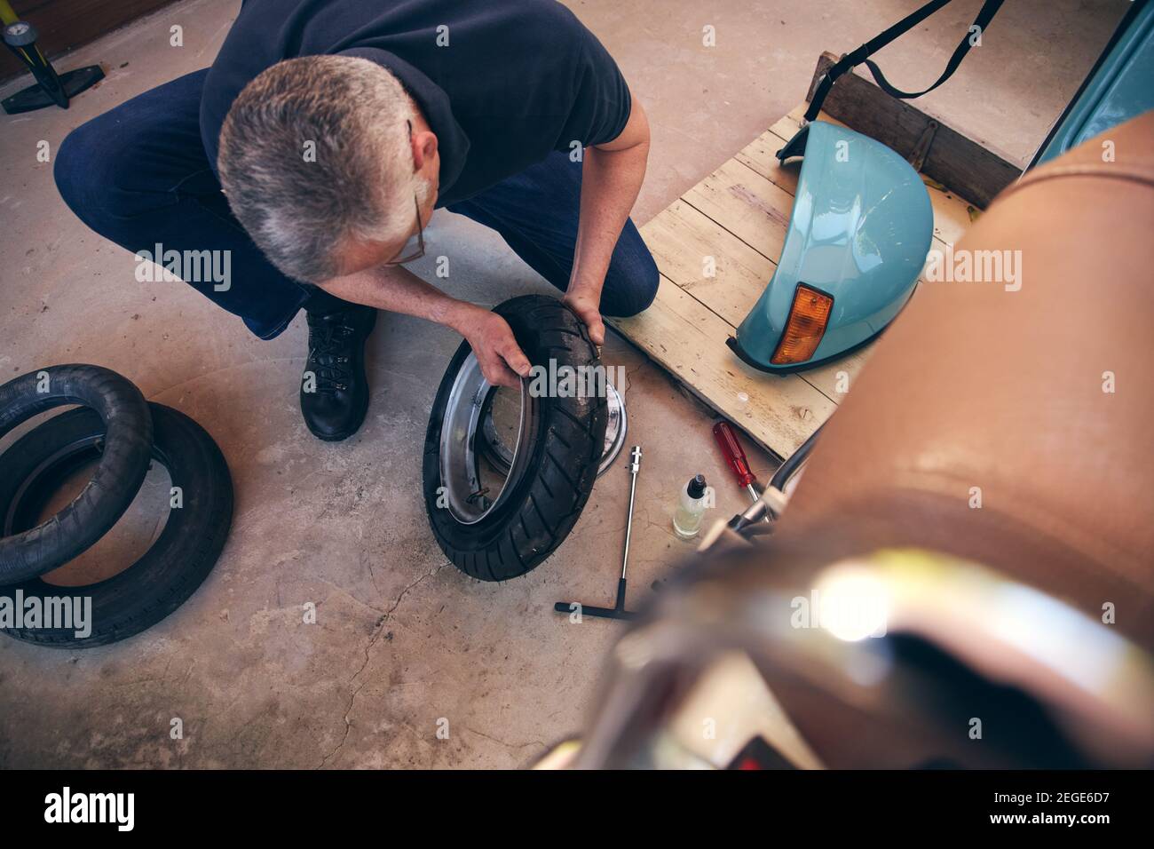 Senior Mann arbeitet an Home Hobby Projekt Befestigung Fahrradreifen Stockfoto
