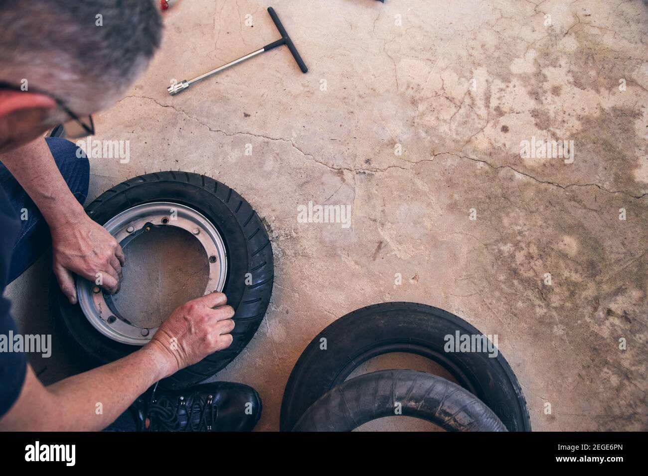 Senior Mann arbeitet an Home Hobby Projekt Befestigung Fahrradreifen Stockfoto