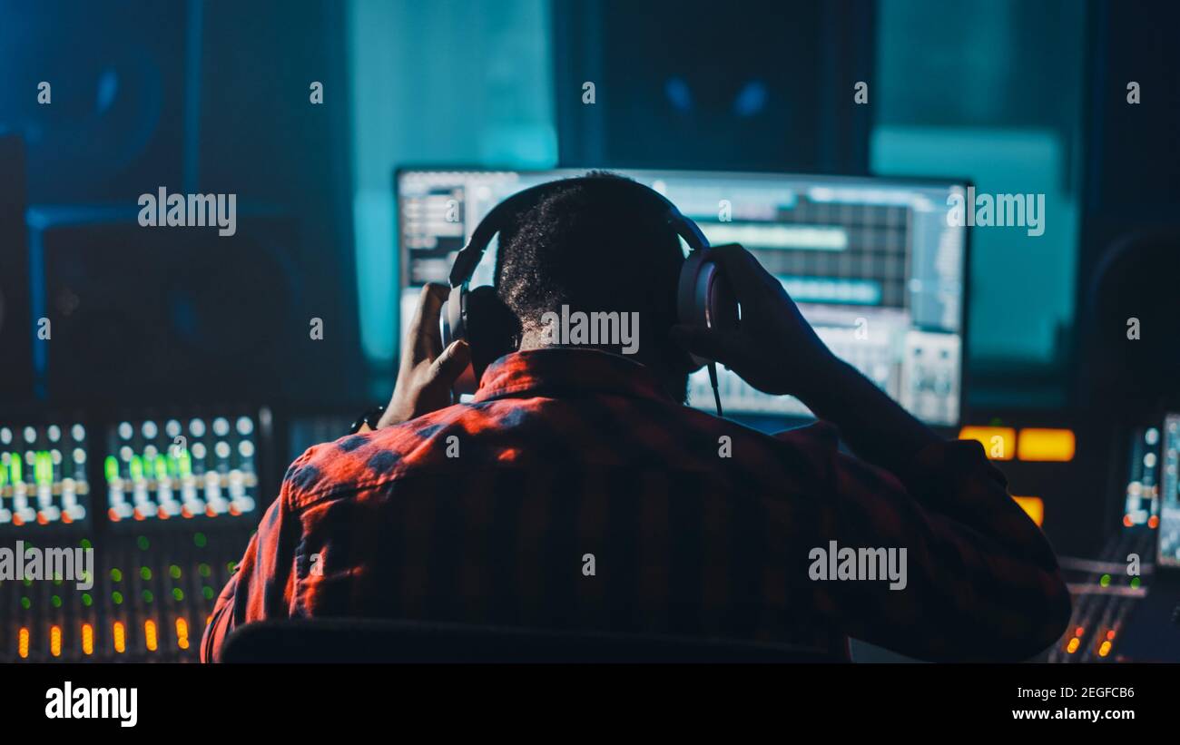 Stilvoller Künstler, Musiker, Audio-Ingenieur, Produzent findet an seinem Control Desk in Music Record Studio, verwendet Computer-Bildschirmanzeige Benutzeroberfläche von Stockfoto